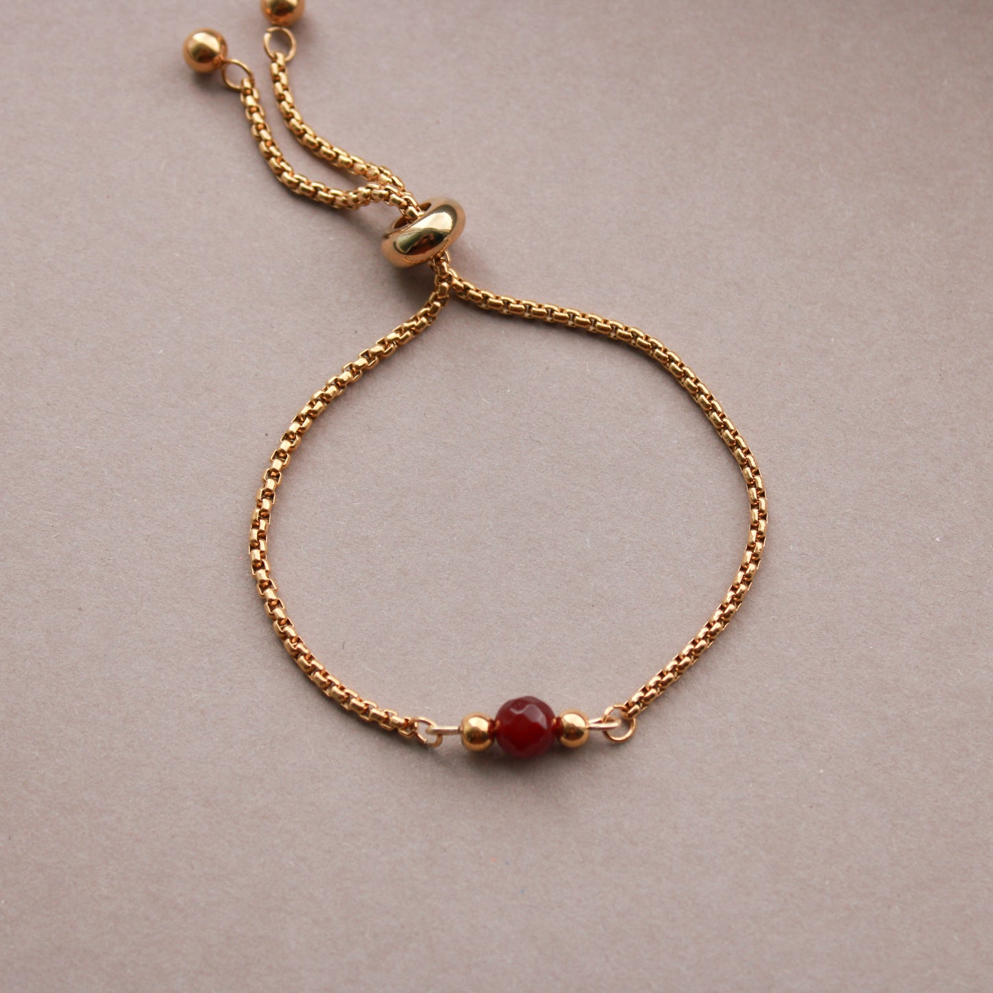 Armband in Gold mit kleiner Natursteinperle in Dunkelrot, Edelstahl