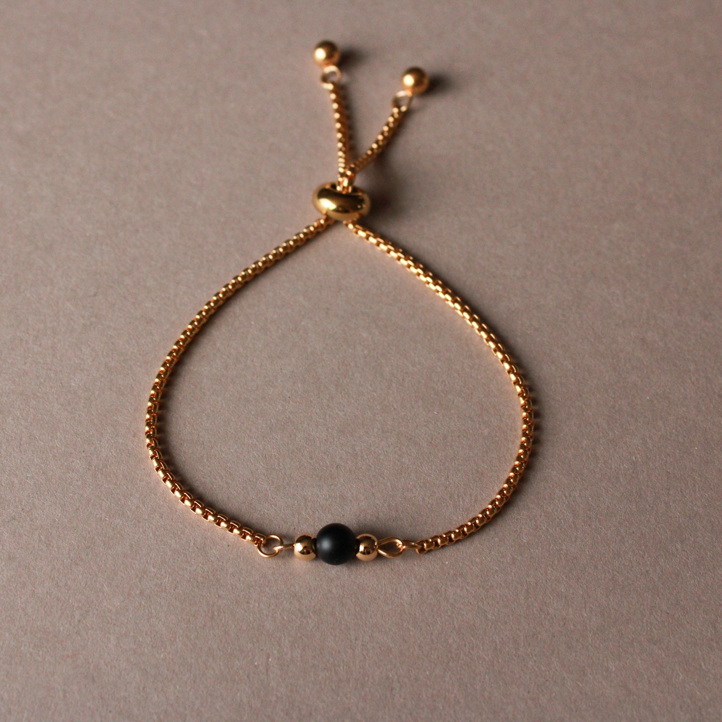 Armband in Gold mit kleiner Natursteinperle in Schwarz, Edelstahl