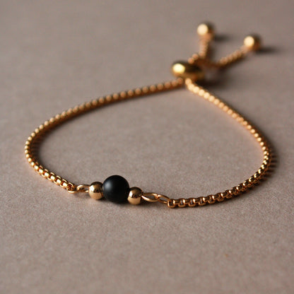 Armband in Gold mit kleiner Natursteinperle in Schwarz, Edelstahl