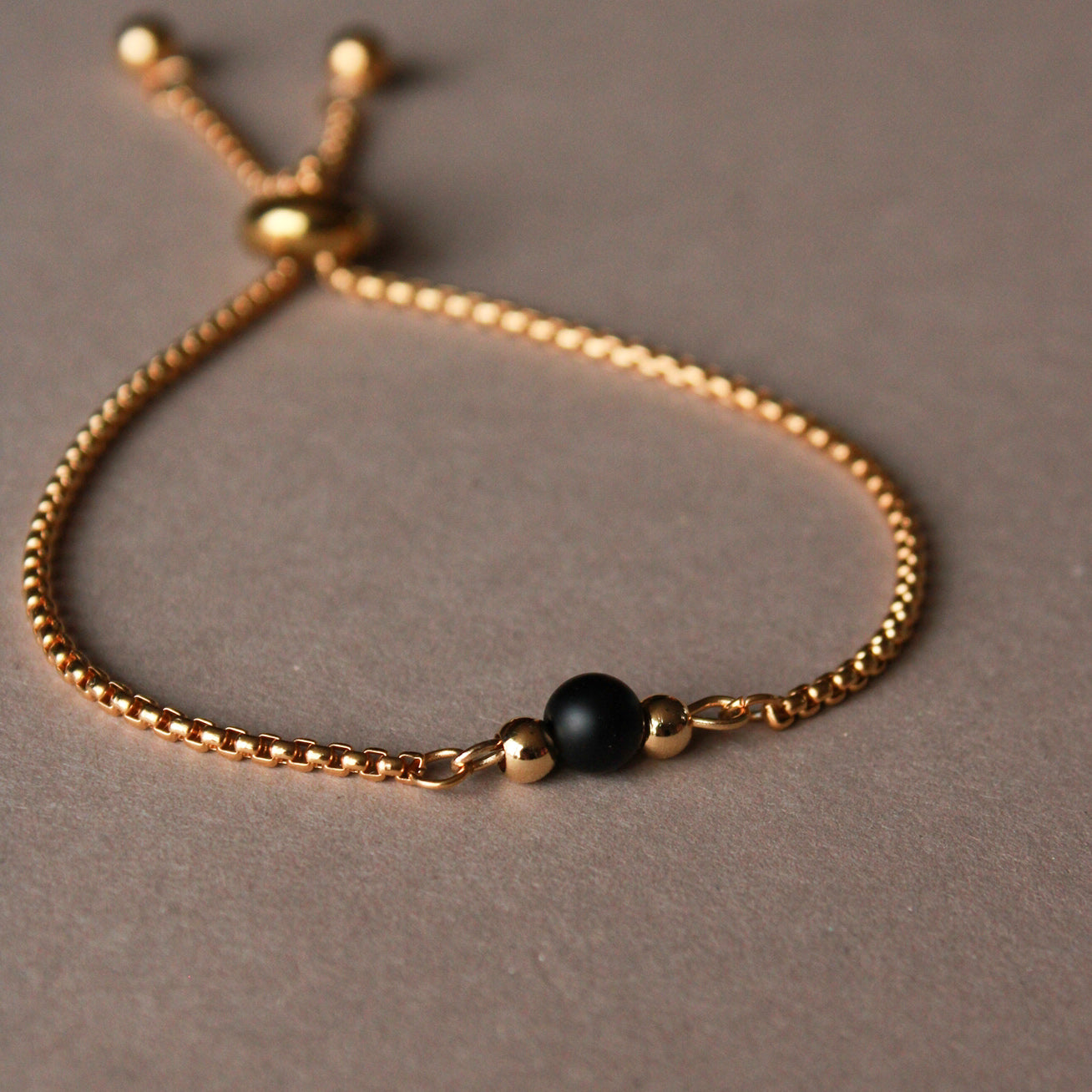 Armband in Gold mit kleiner Natursteinperle in Schwarz, Edelstahl