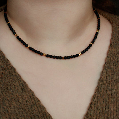 Schwarze Perlenkette mit vergoldeten Edelstahlperlen