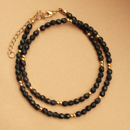 Schwarze Perlenkette mit vergoldeten Edelstahlperlen